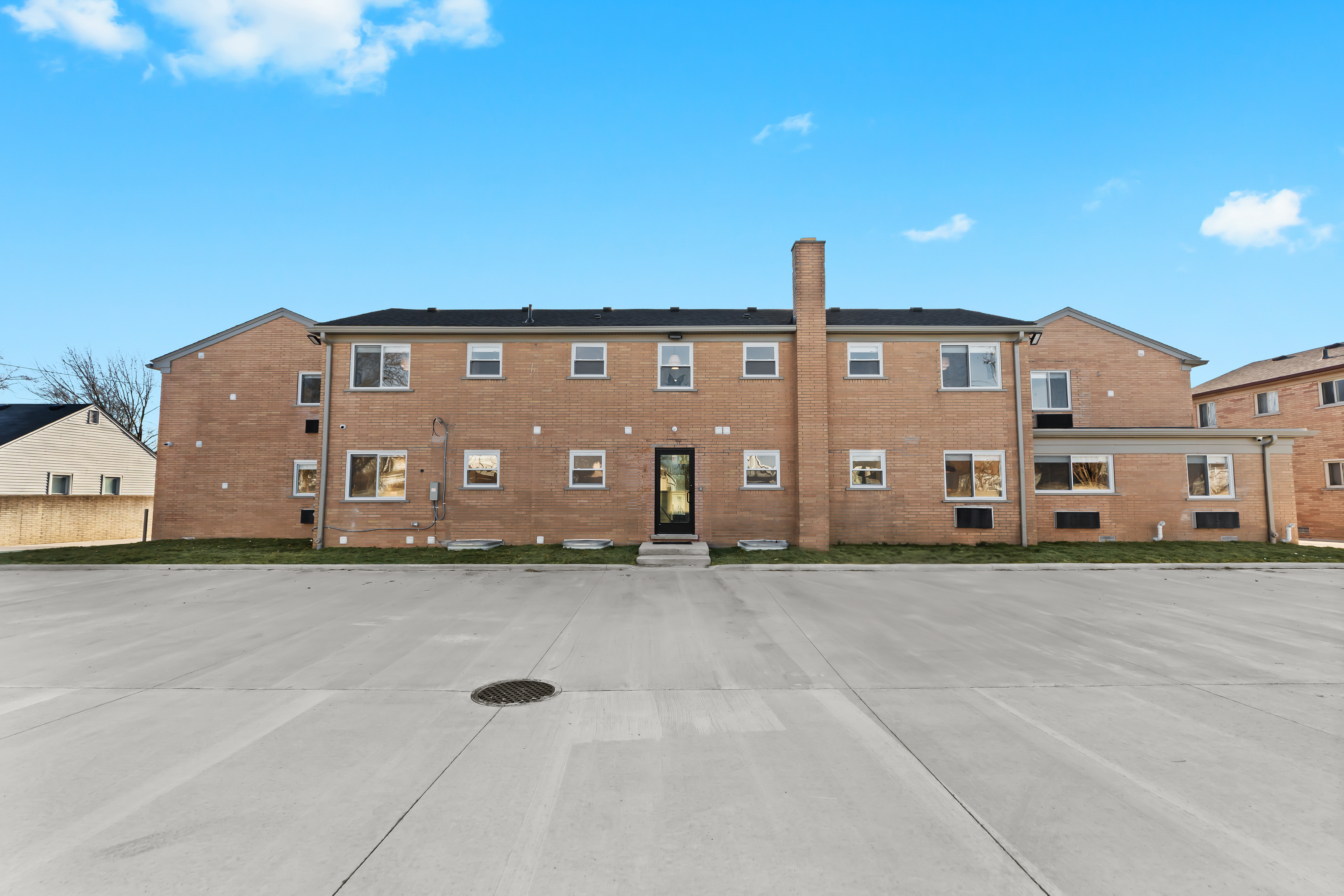 A well-maintained brick building with easy parking and a welcoming entrance, offering a quiet, convenient place to call home during your stay.