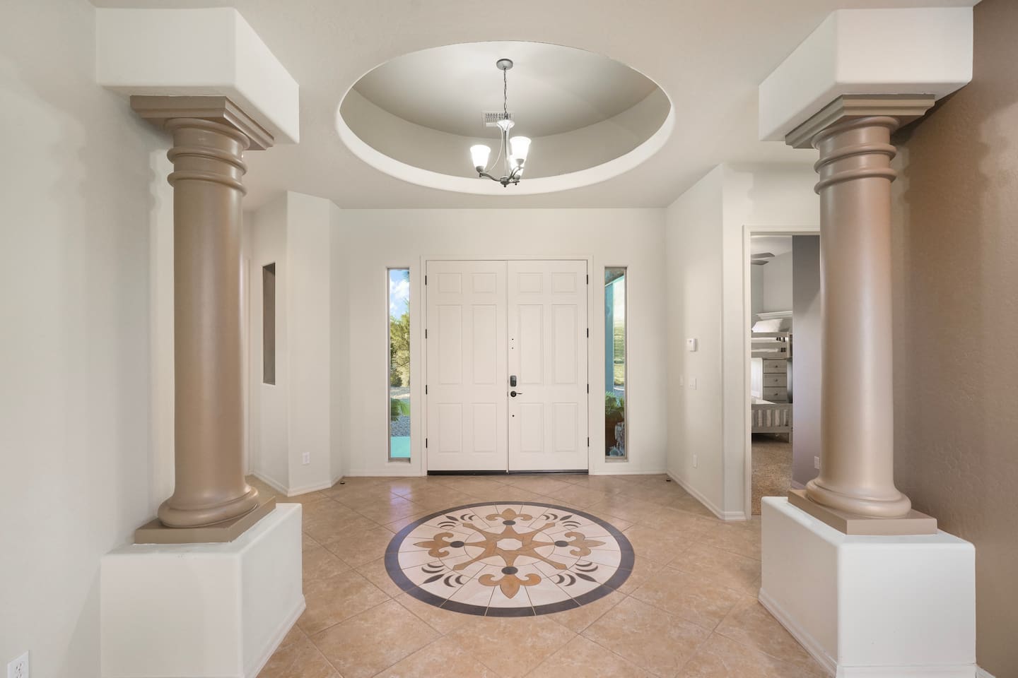 Elegant foyer showcasing classic columns, a circular ceiling detail, and a welcoming layout