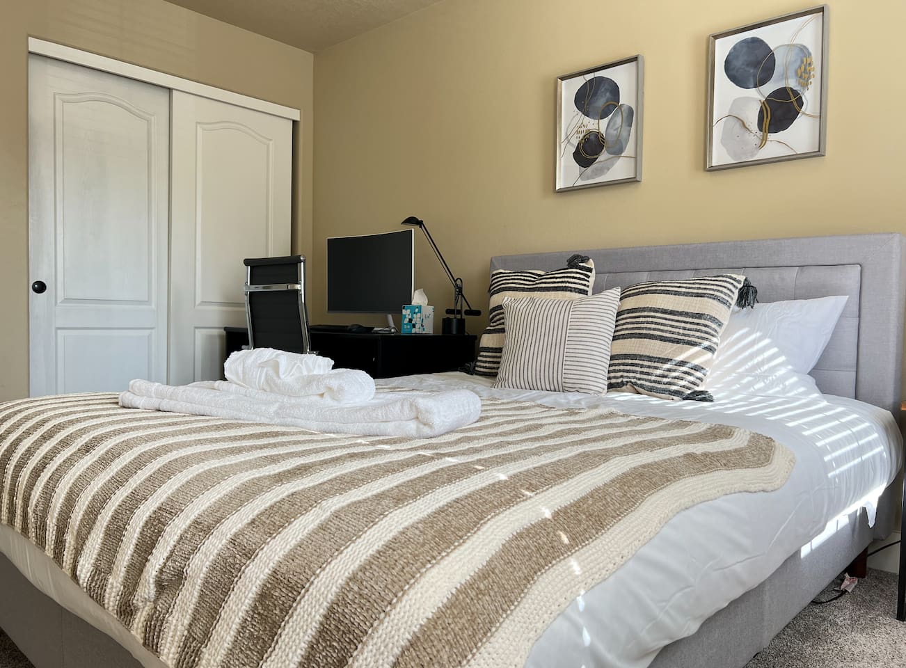 This bedroom has a queen bed and an office set up. 