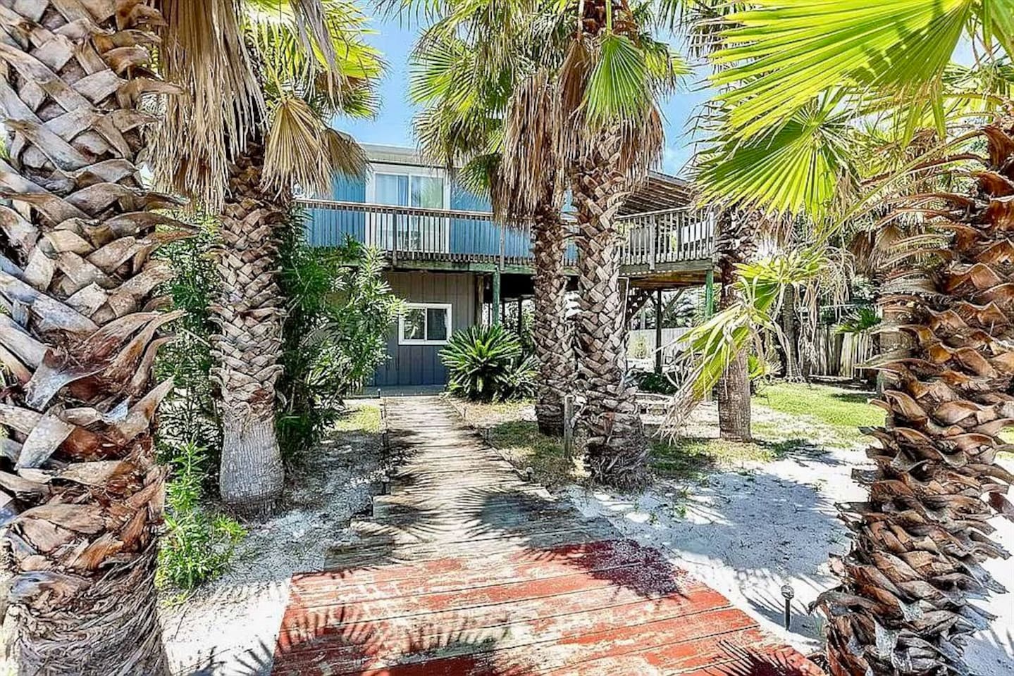 Tropical Oasis Entrance: Stroll through lush palms to your Fort Morgan getaway paradise!