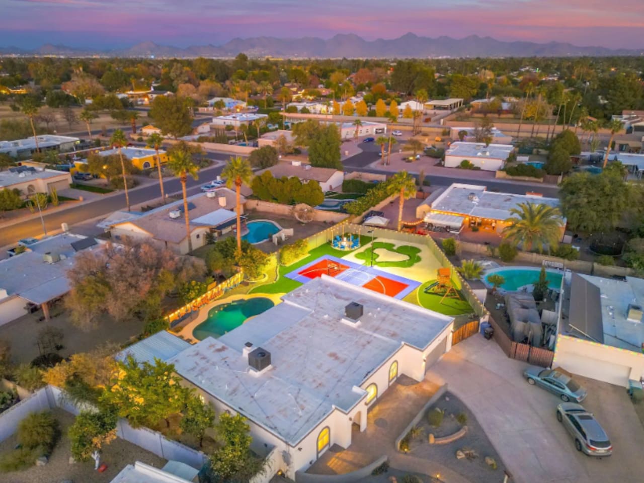 A backyard built for a crowd: pool, sport court, and putting green, all on one oversized lot.