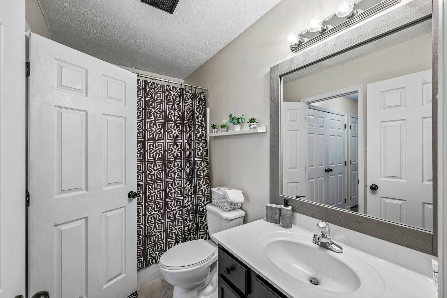 Bright and clean bathroom with a modern vanity, shower/tub combo, and fresh towels provided. Thoughtful touches like storage baskets and décor make it feel comfortable and welcoming.