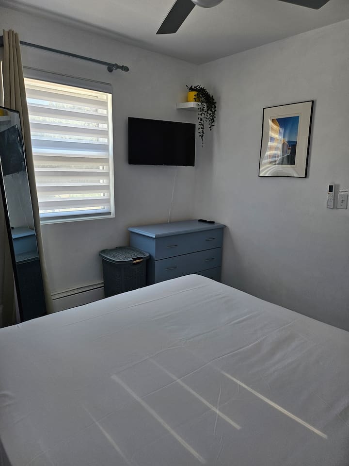 Flat screen App TV and chest of drawers for storage, room darkening curtains