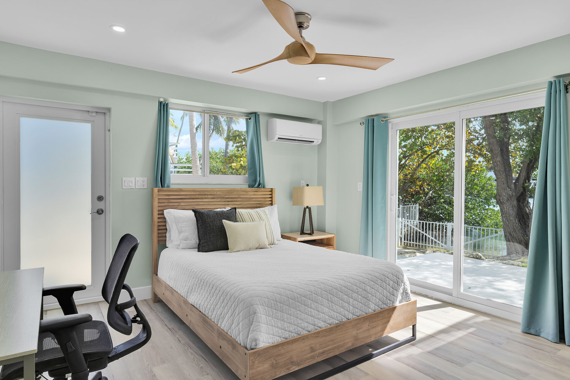 Downstairs guest bedroom with queen bed, desk and chair. 