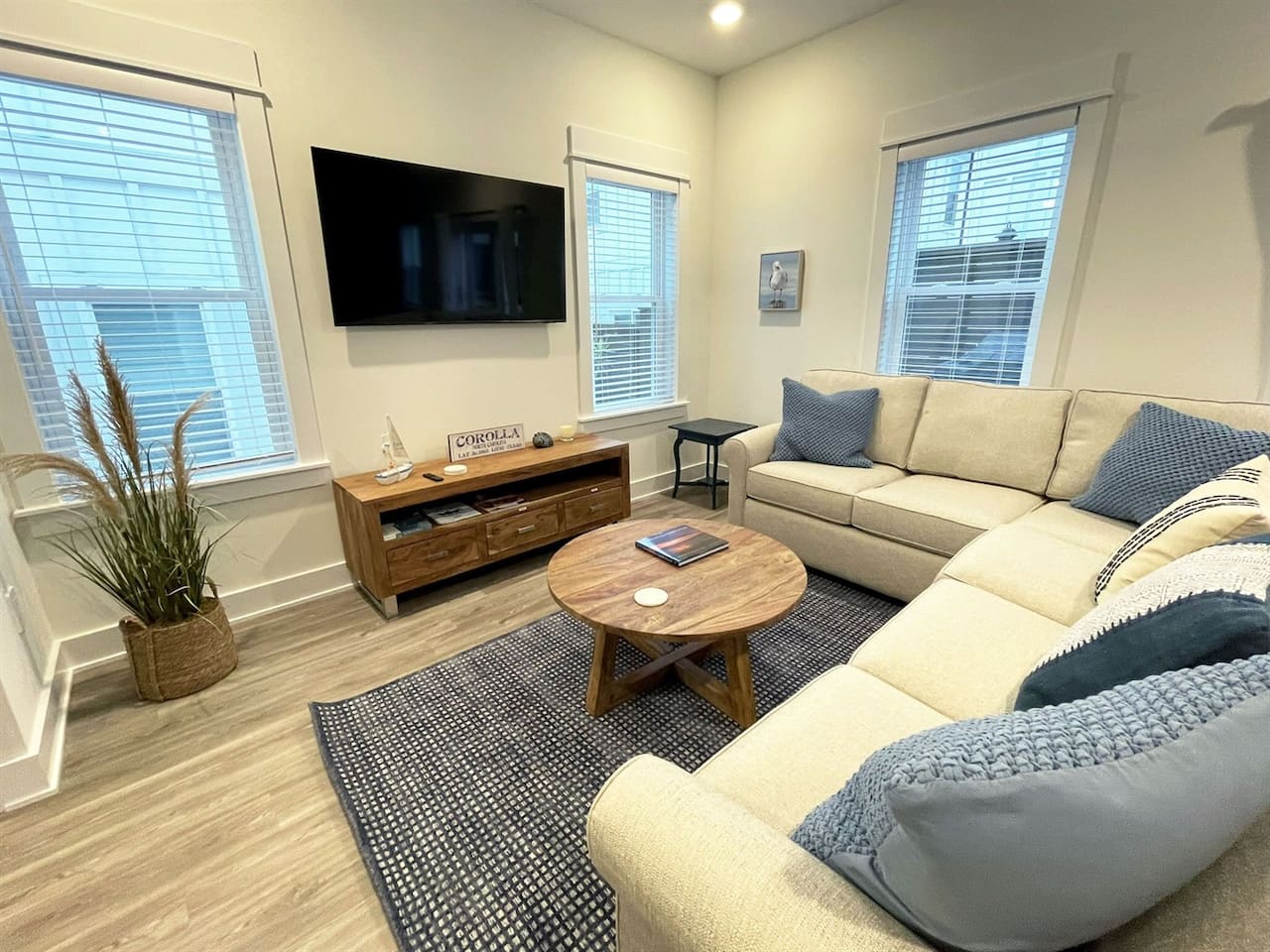 Inviting living area with plush sectional sofa, wall-mounted TV, and plenty of natural light for family movie nights or quiet evenings in.