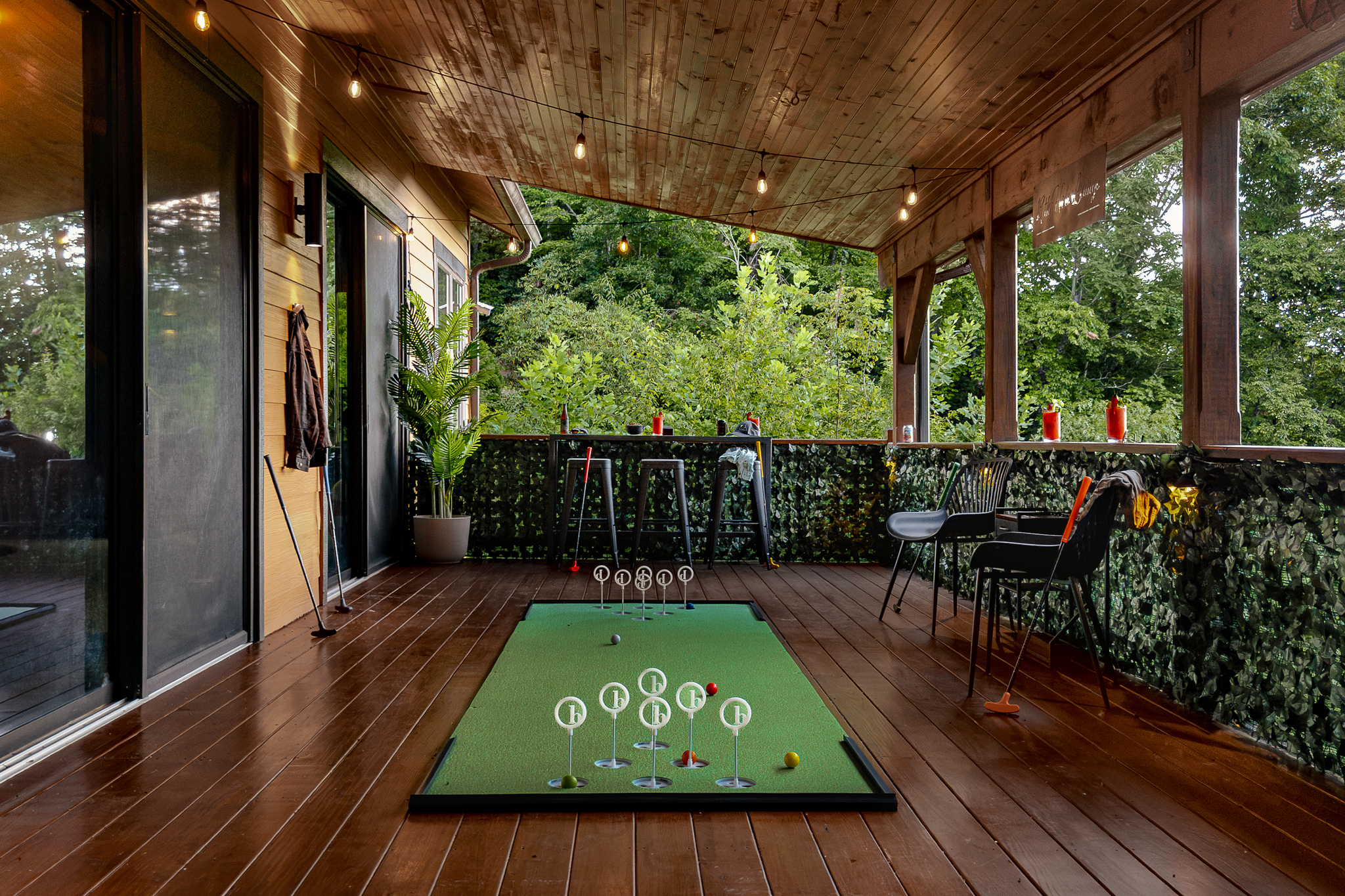 {19th Hole Deck} Your private covered game deck features mini golf, bar seating, games, and forest views for a little friendly competition.