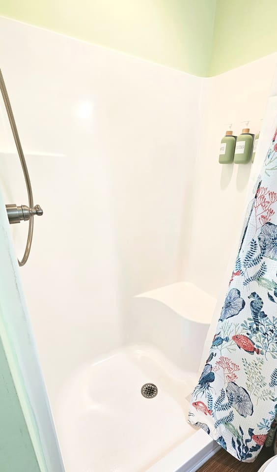 handicap shower with sit down ledge. Shampoo, Conditioner, and soap.