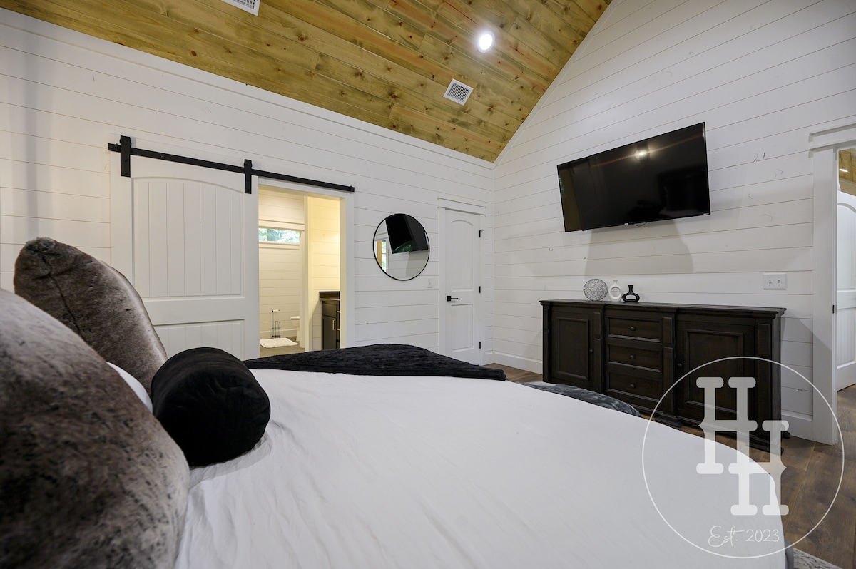 Master bedroom leading into the master bathroom. Smart TV, ceiling fan