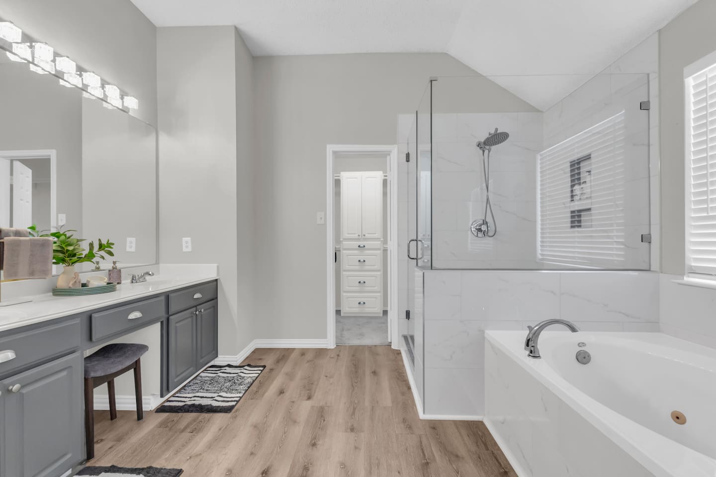 Huge primary bathroom featuring a separate walk-in shower, jacuzzi-style soaking tub, double vanity, fresh towels, hairdryer, shampoo, conditioner, and shower gel.