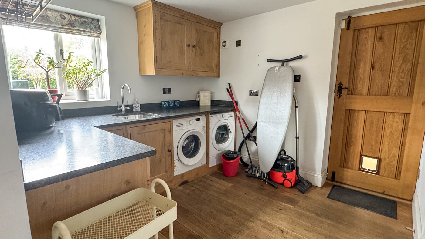 Utility room with washer, dryer, vacuum cleaner and ironing board