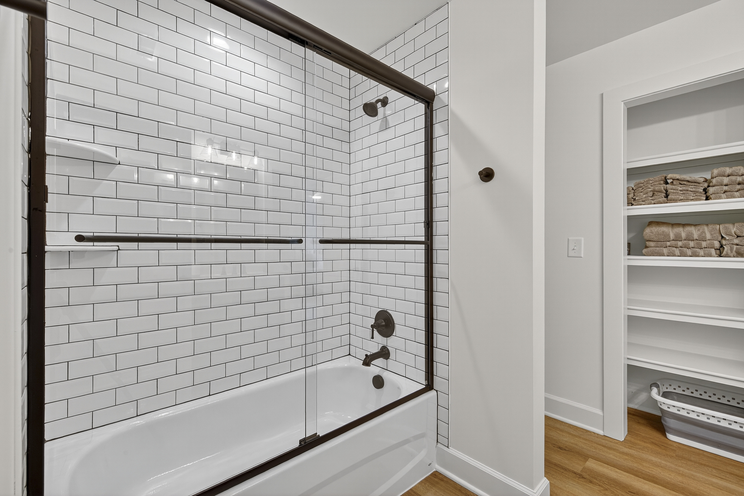 Stylish tub/shower combo with sleek subway tile and modern fixtures.