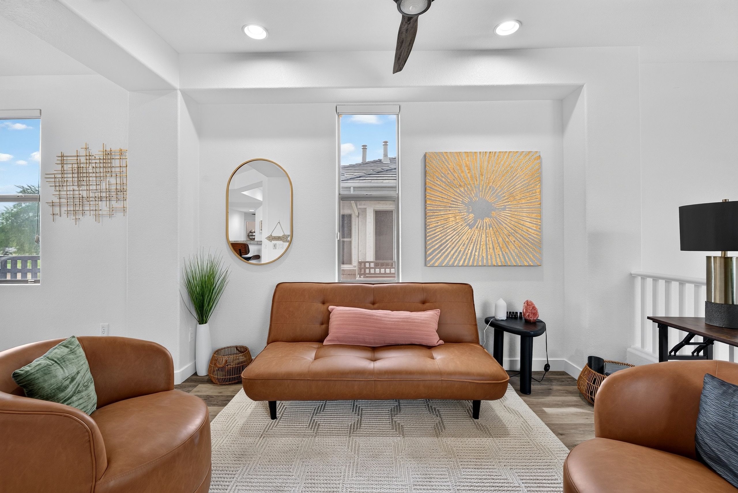Open sitting area with accent chairs, sofa seating, natural light, and easy flow to the dining and living spaces.