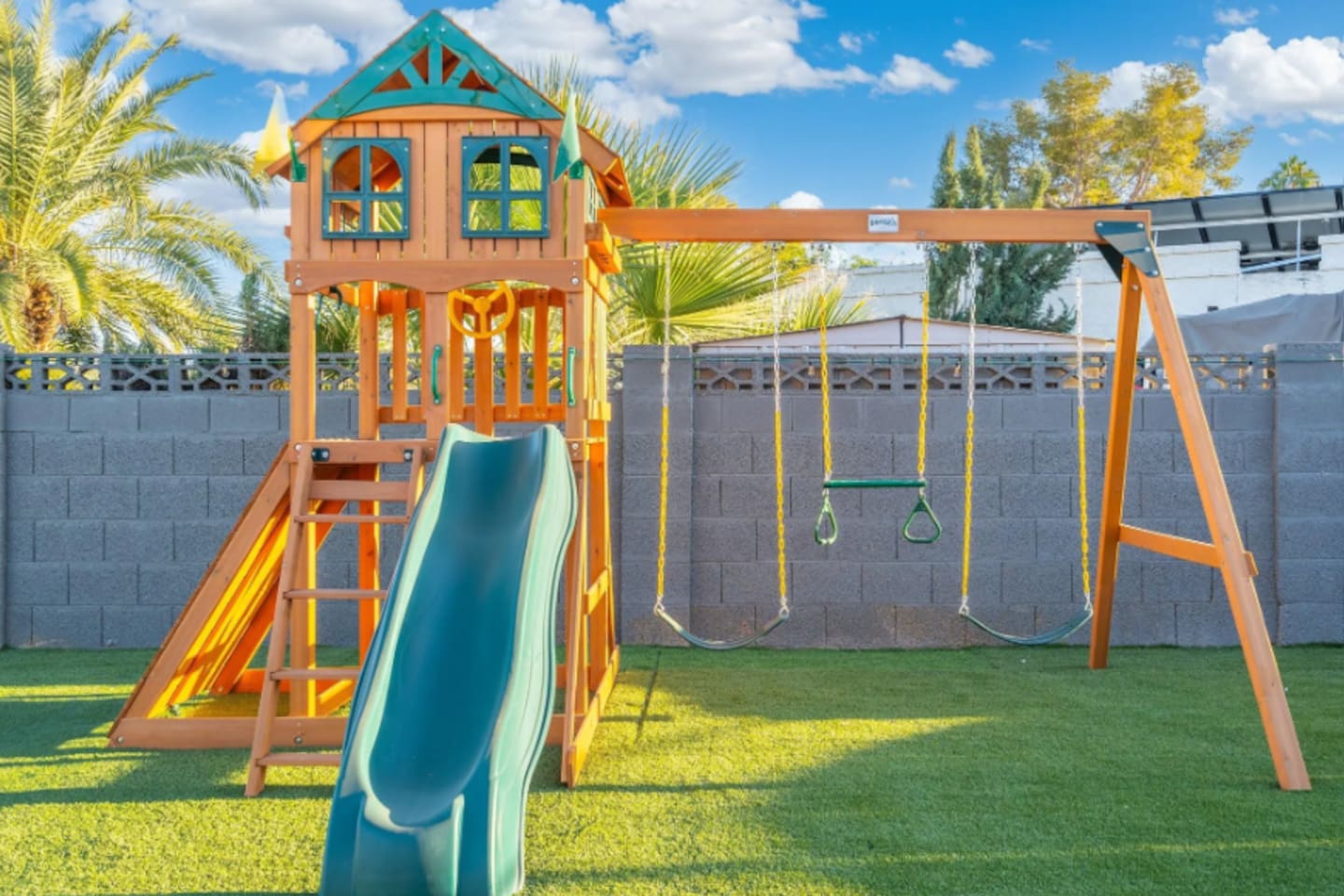 A dedicated play structure with a slide and swings gives younger guests their own corner of the yard to burn off energy.
