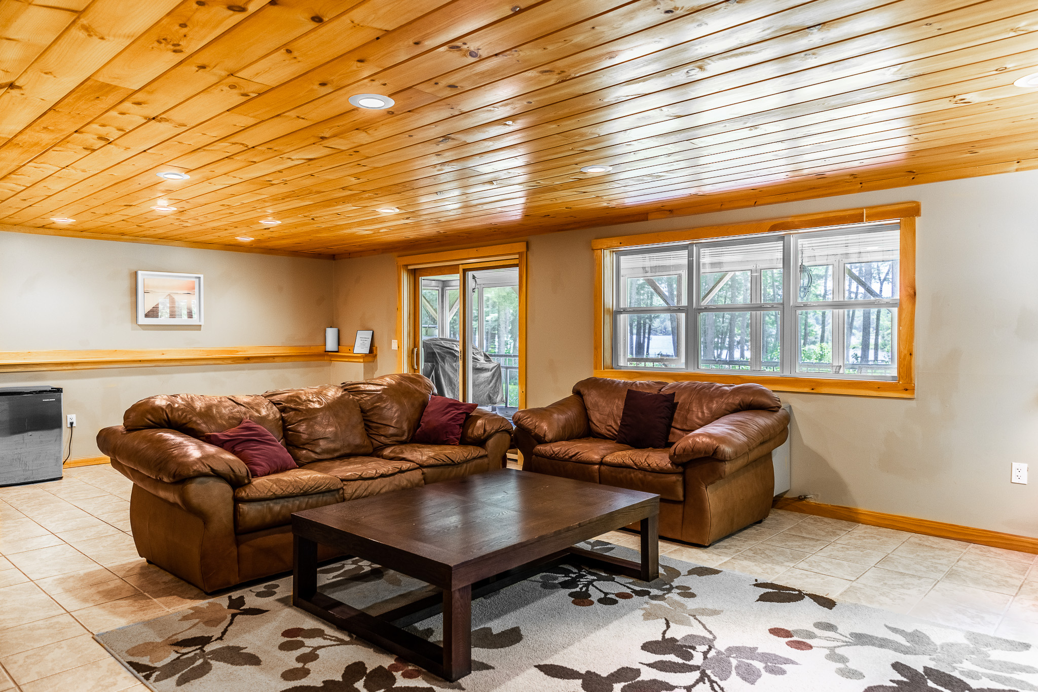 Downstairs entertainment area with comfortable leather couches, Roku TV, DVD player with some movies, drink refrigerator, access to covered and screened outdoor kitchen area.