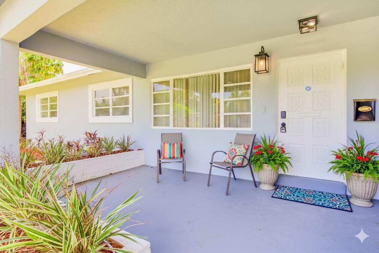 Charming front porch with cozy seating, lush plants, and a welcoming entry—perfect for morning coffee or quiet moments outdoors.