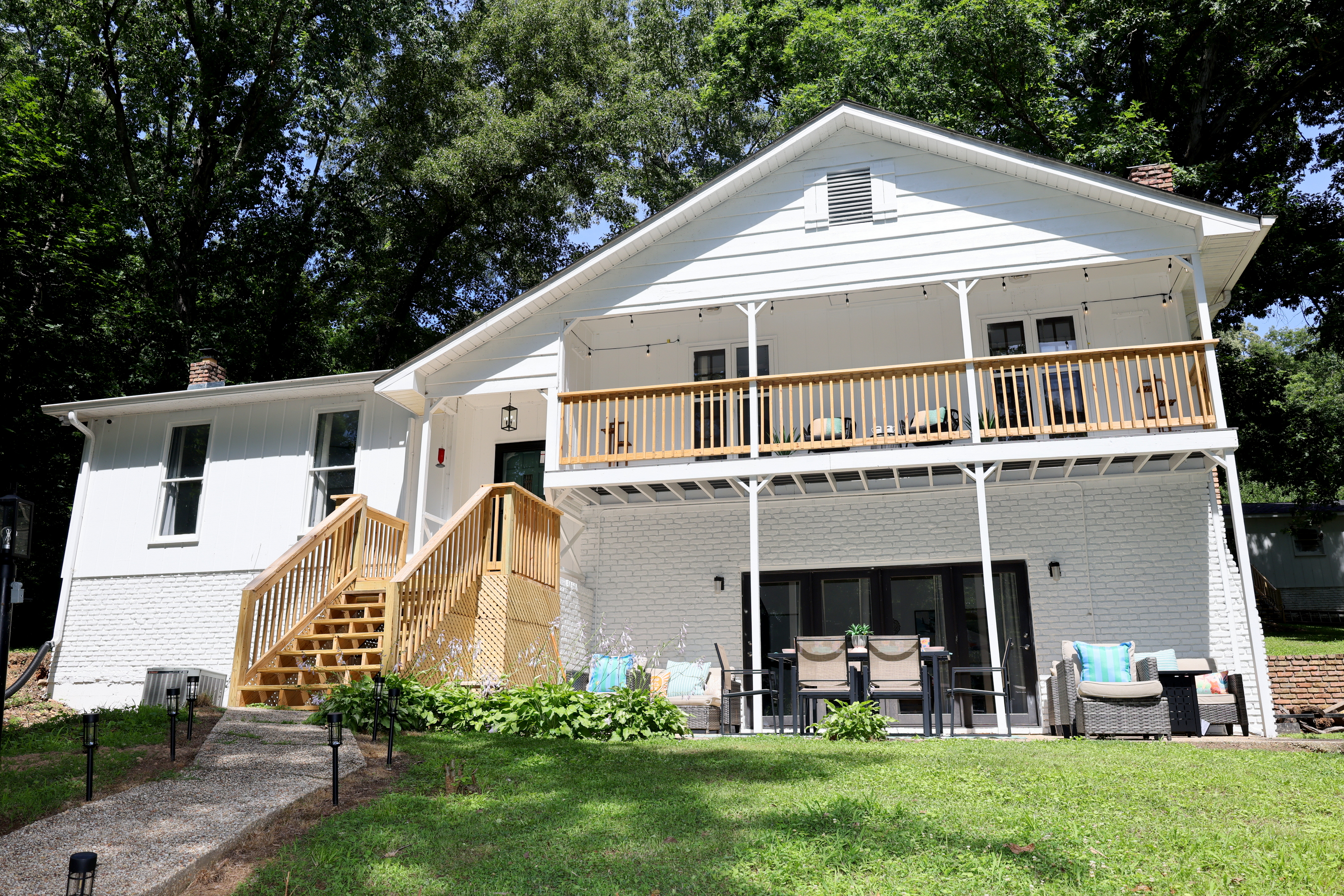 Exterior view of the lake house with deck, patio seating, and beautiful outdoor space