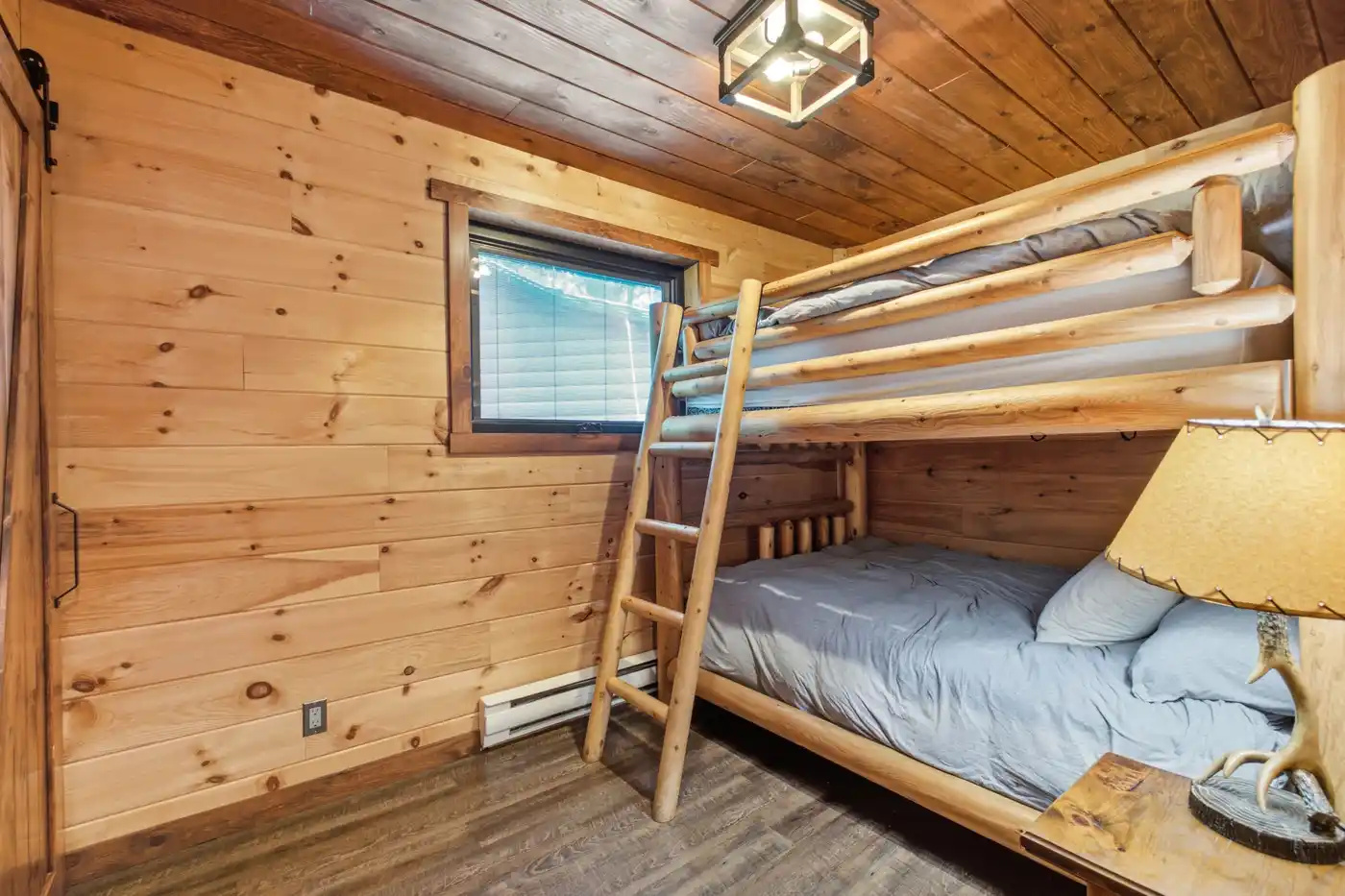 Bunk room with multiple sleeping spaces and natural wood walls
