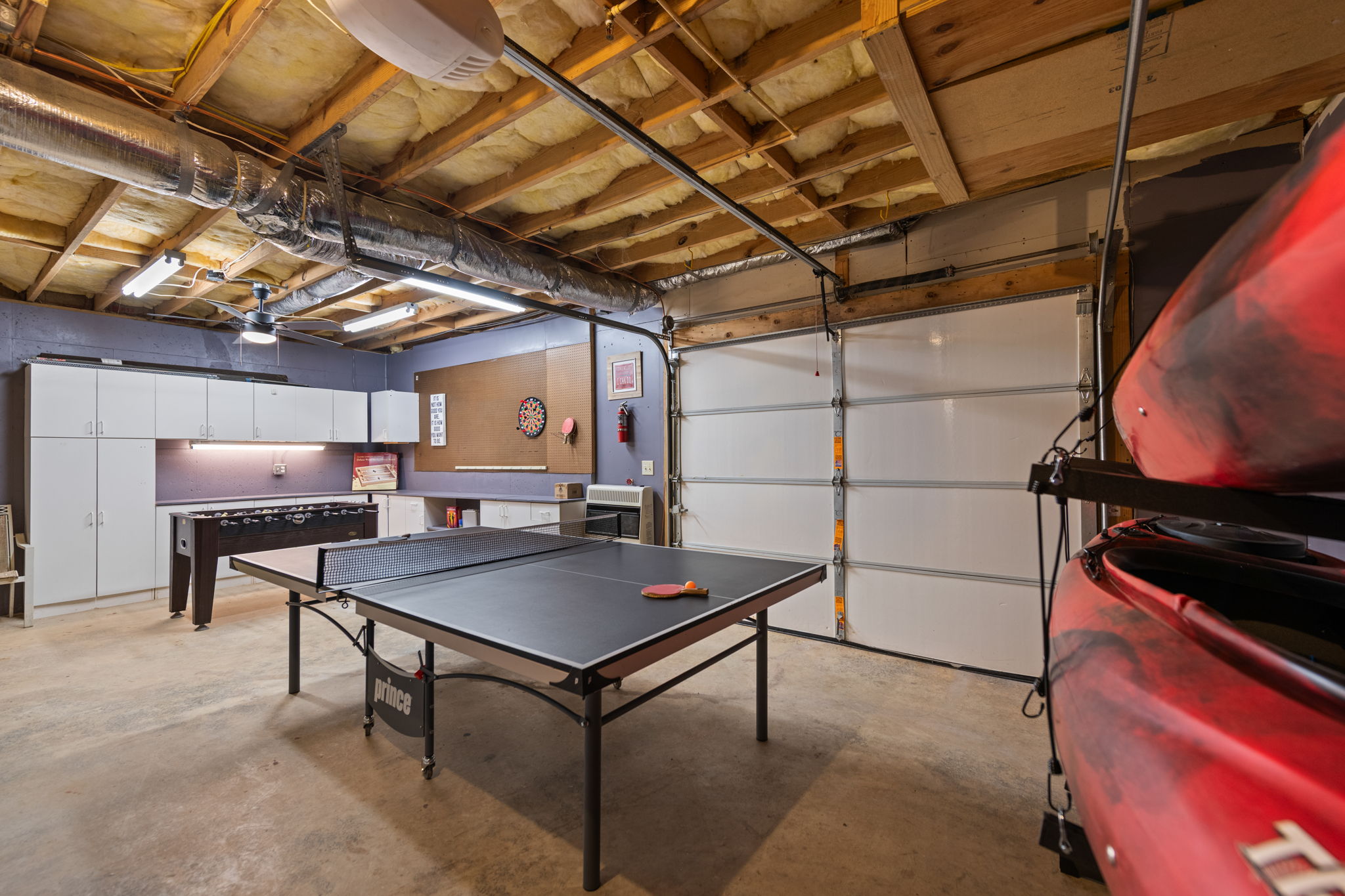 The converted garage game room is packed with fun, offering table tennis, arcade games, foosball, and darts for endless entertainment.