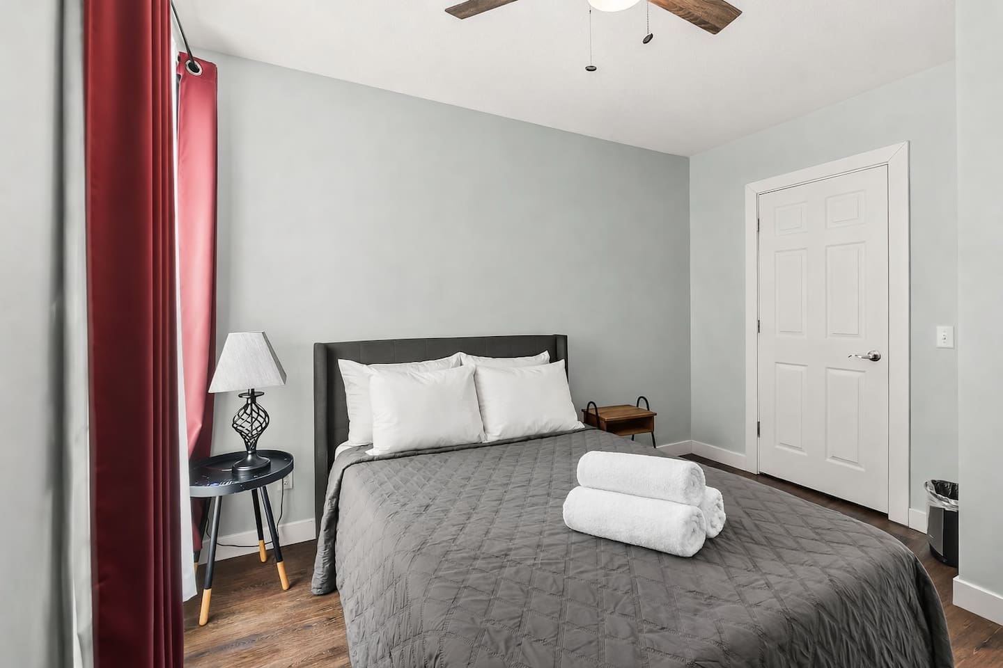 Bright bedroom view with full-size bed, nightstands, and soft natural light from the window.