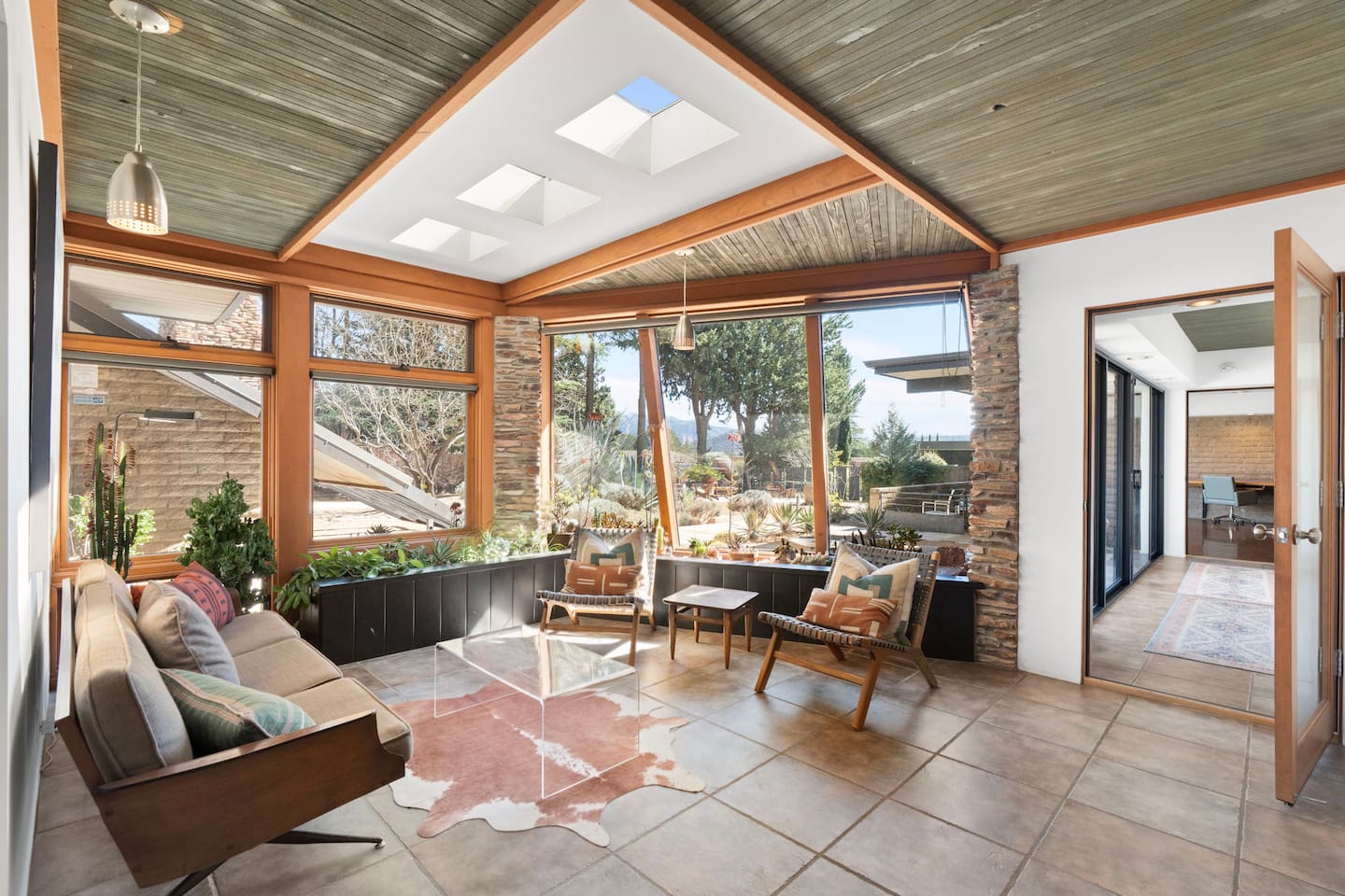 Sun-filled lounge with panoramic views, skylights, and chic mid-century design.