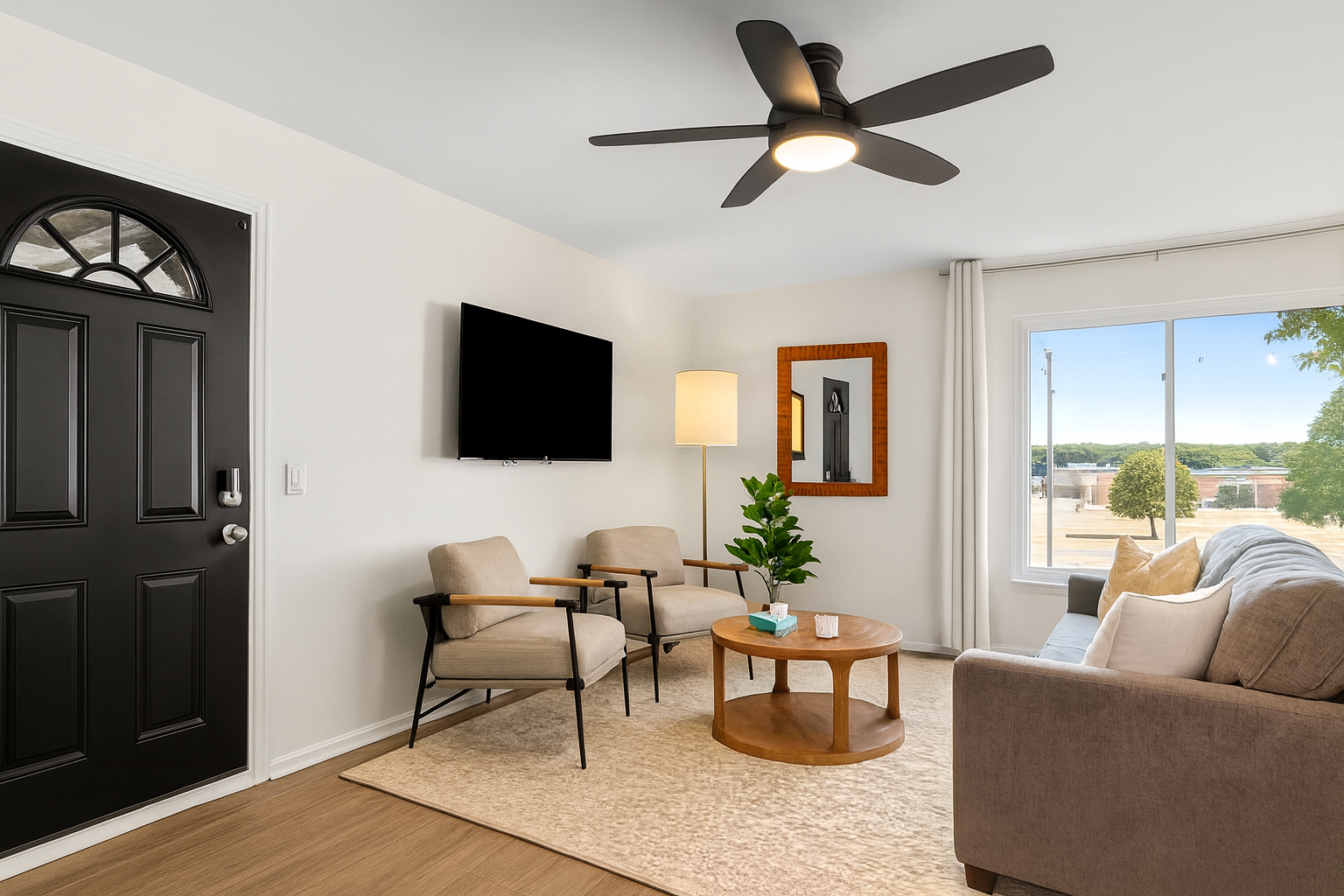 Relax in this sunlit living room, complete with a comfy sofa, leafy views, and a large Smart TV.