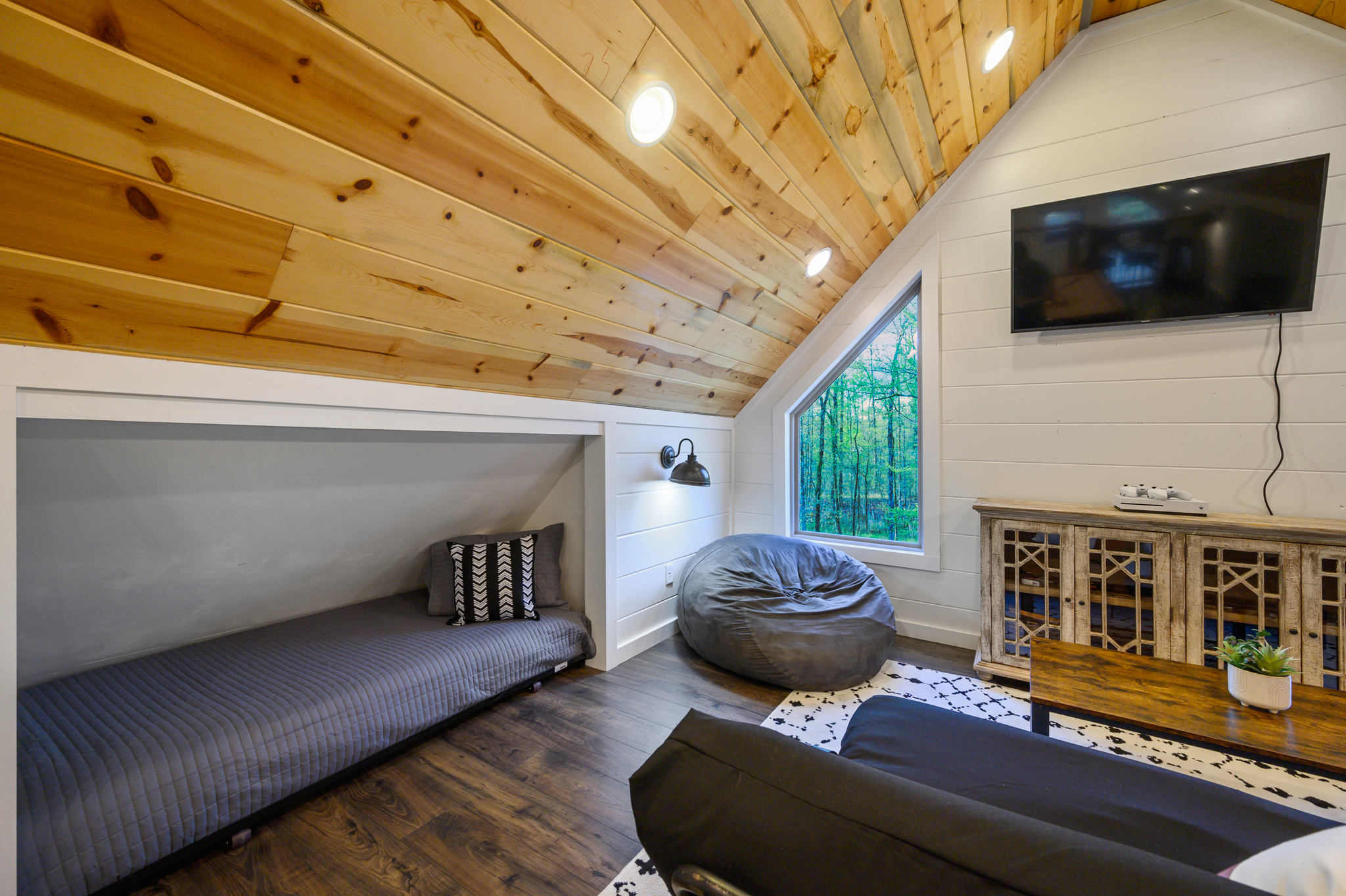 Boots + Beats | One of four roll-out twin beds in the game loft. The cabin sleeps eight guests total.