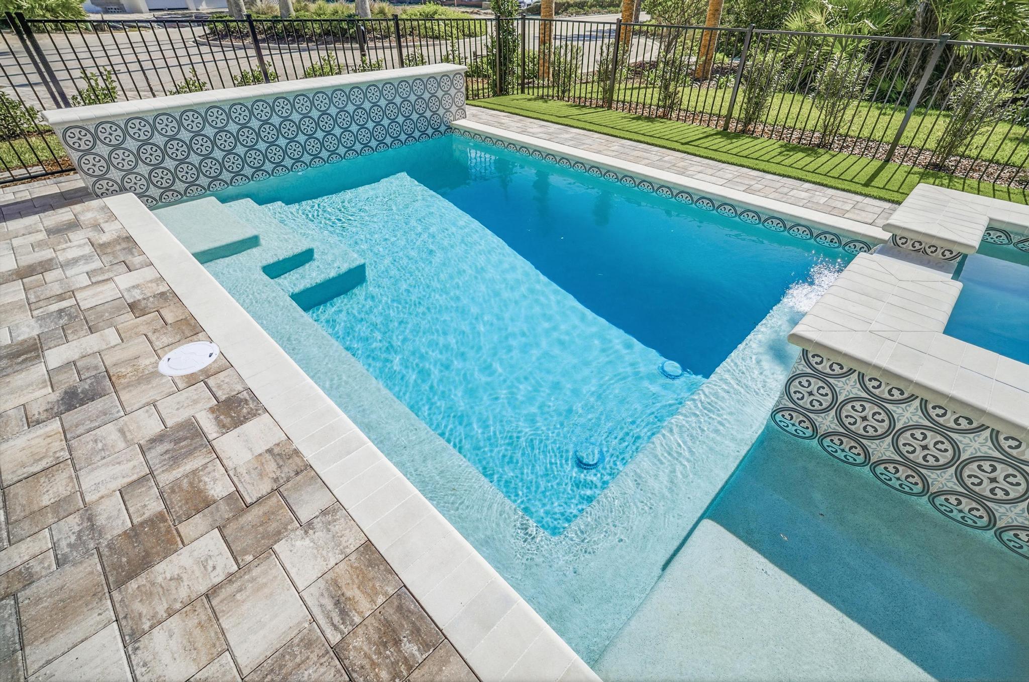 Ease into the sun-shelf with your coffee, let the kids claim the steps, and watch the water shimmer against patterned tile—this is where mornings start slow and afternoons disappear in a perfect blue hush.

