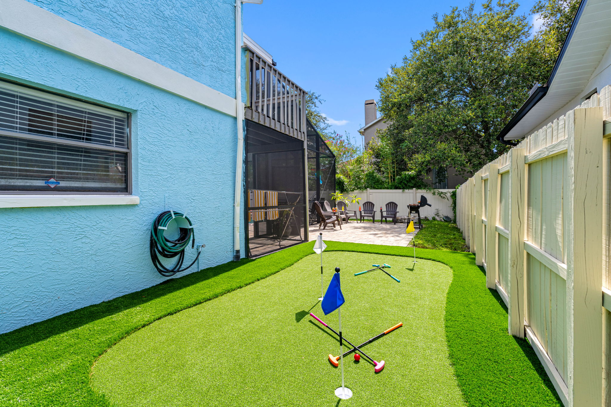 This unique side yard is home to a playful putting green and bright cornhole boards—great for casual fun or a little friendly competition.
