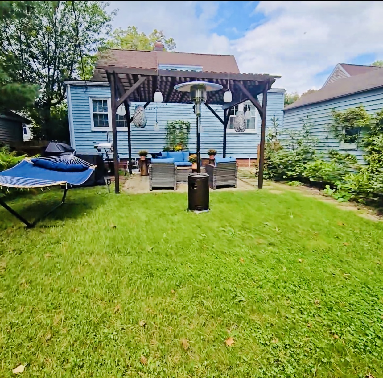 Backyard comfort at its finest—stretch out in the hammock, warm up by the patio heater, and gather under the pergola with the patio set nearby. Solar lanterns add a soft glow as the evening unfolds.
