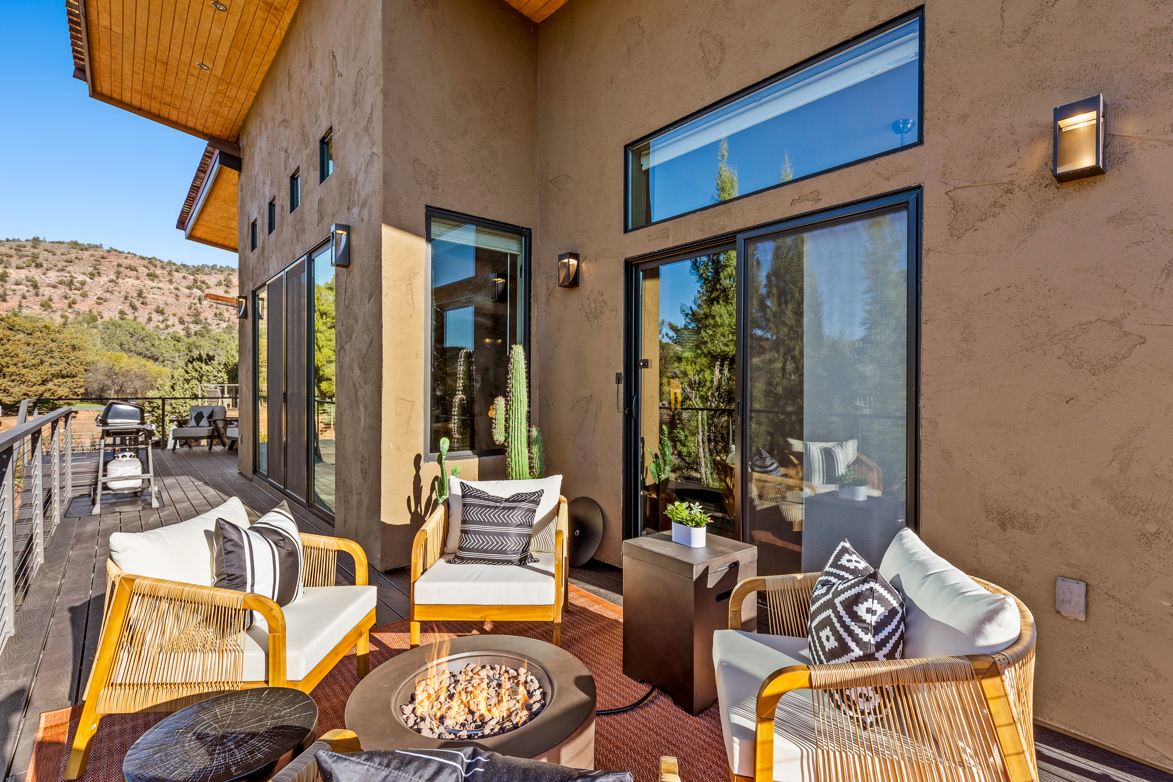 A comfortable outdoor lounge on the upper deck with seating and a fire feature, designed for relaxing, gathering, and enjoying Sedona’s desert setting.