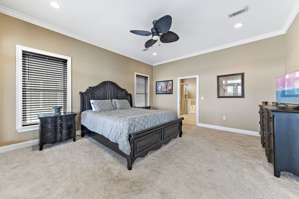 Bedroom with dark wood bed frame and ceiling fan