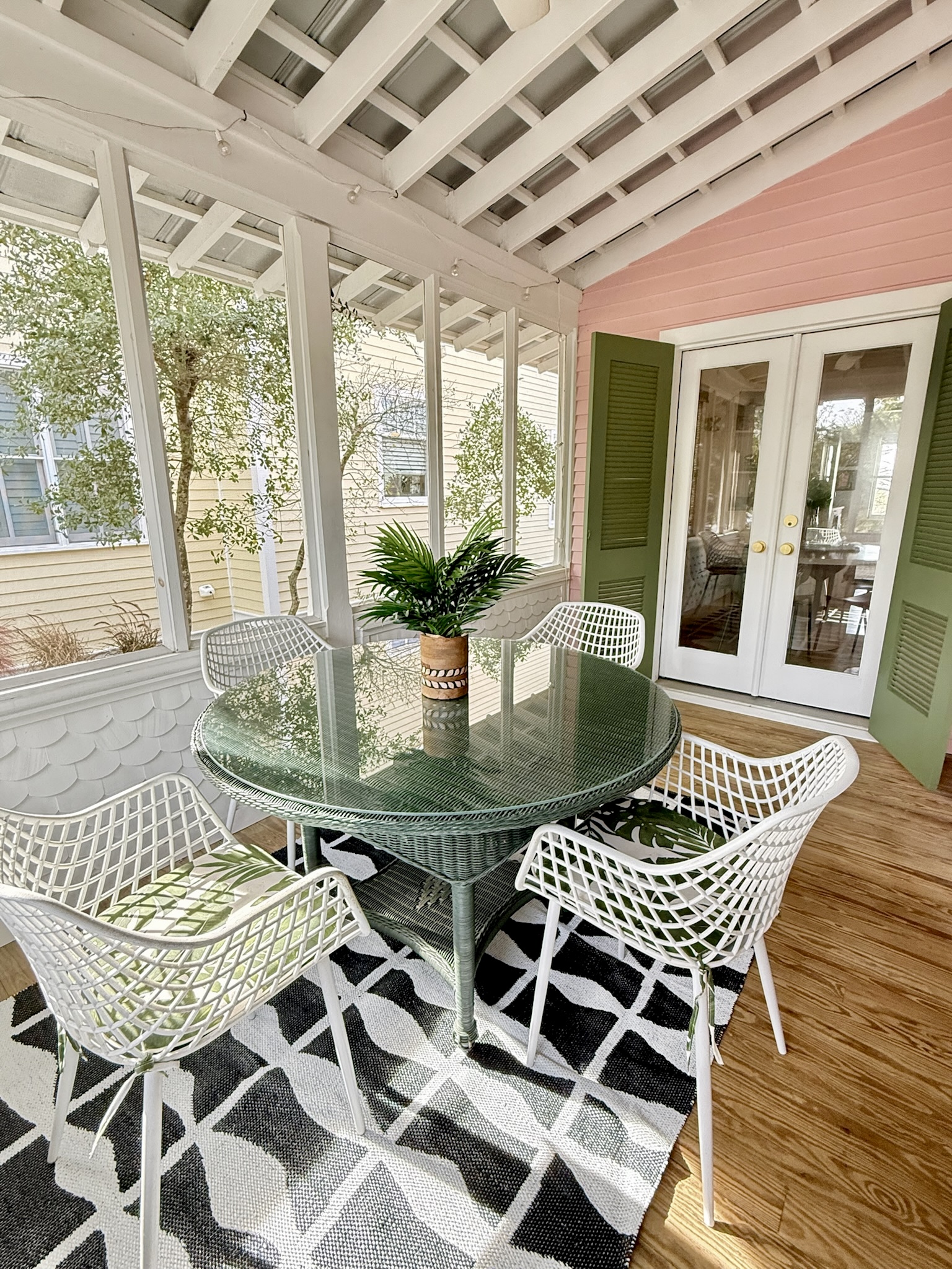 Charming screened porch with outdoor dining—perfect for morning coffee or relaxed coastal meals.