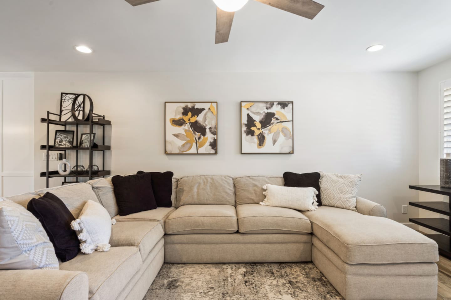 Open living room with large sectional seating, ceiling fan, perfect for gathering!