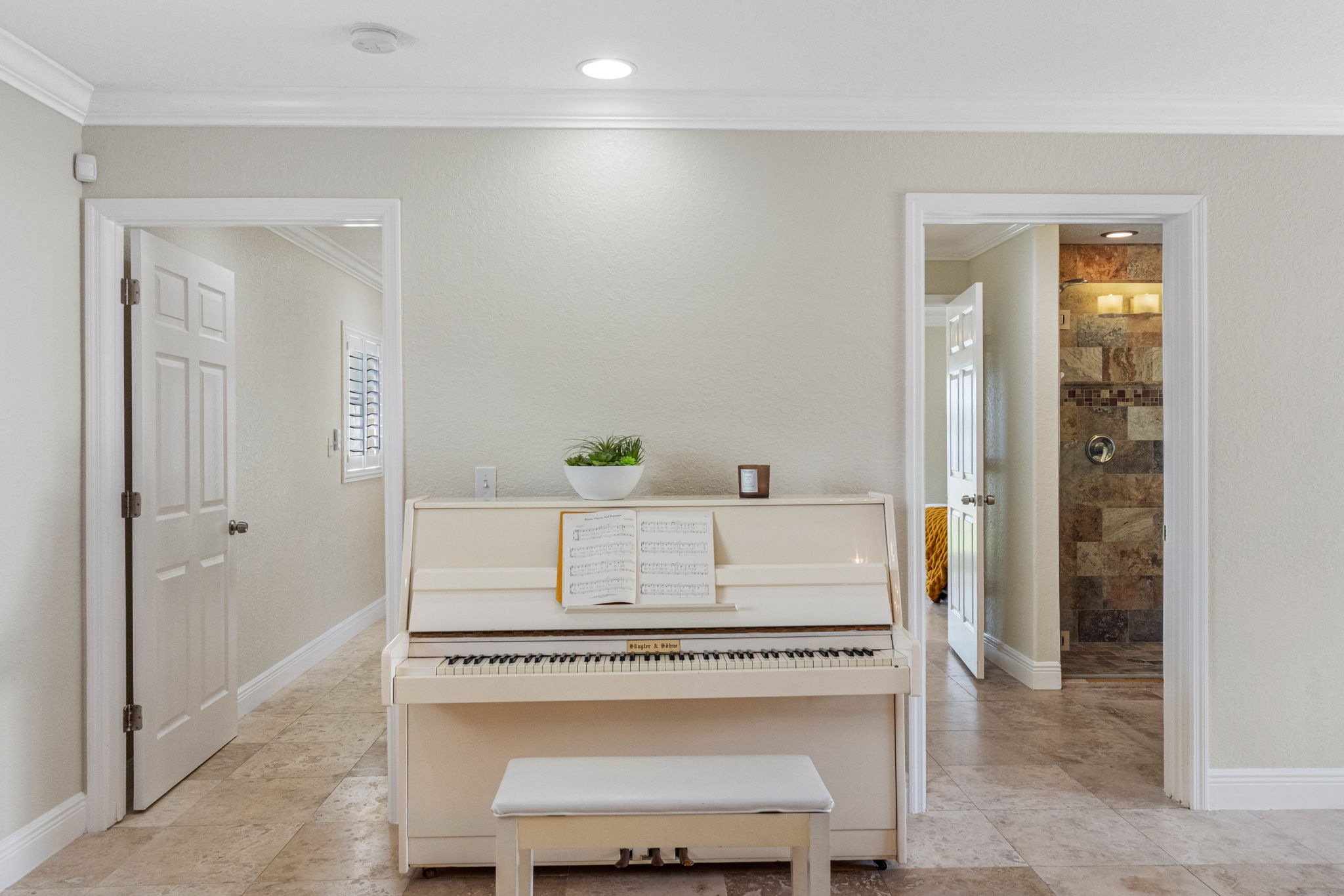 This inviting space features a white upright piano and matching bench, ready for a relaxing play session.