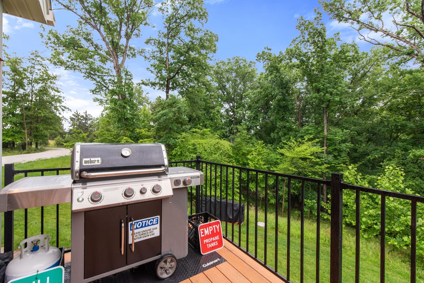 New Weber Genesis gas grill (May 2025). BBQ tongs and spatulas are inside the kitchen island. There will be a propane tank already hooked up, and an extra one in case you need it.