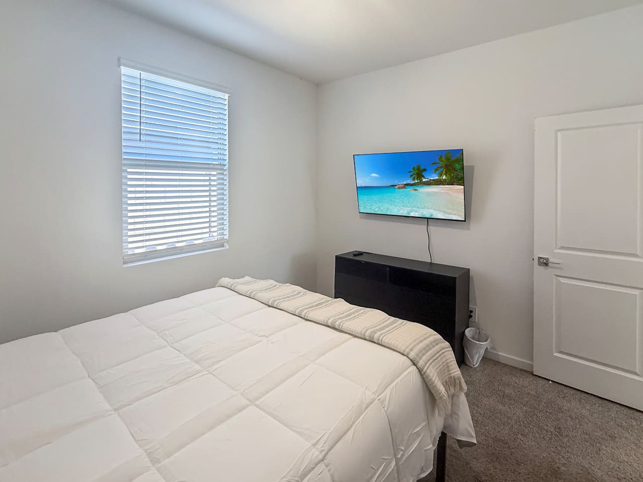 Bedroom with bed, TV on dresser, window, and closet door