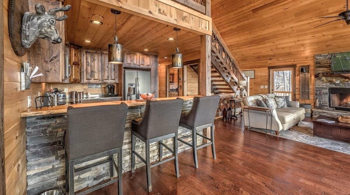 Open living space with kitchen bar seating, vaulted wood ceilings, and seamless flow into the great room for easy entertaining.