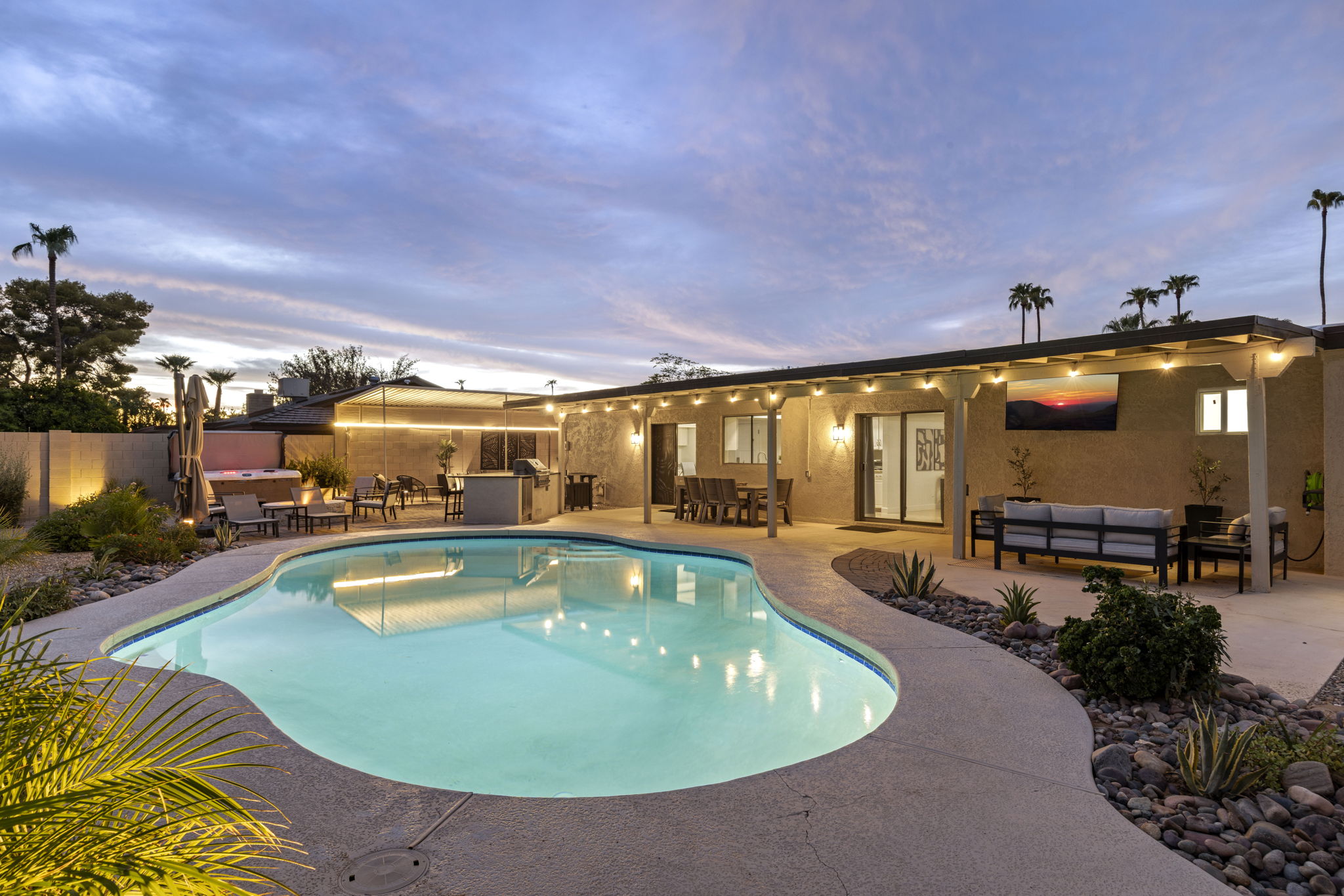 Evening lighting creates a relaxing, resort-style backyard atmosphere