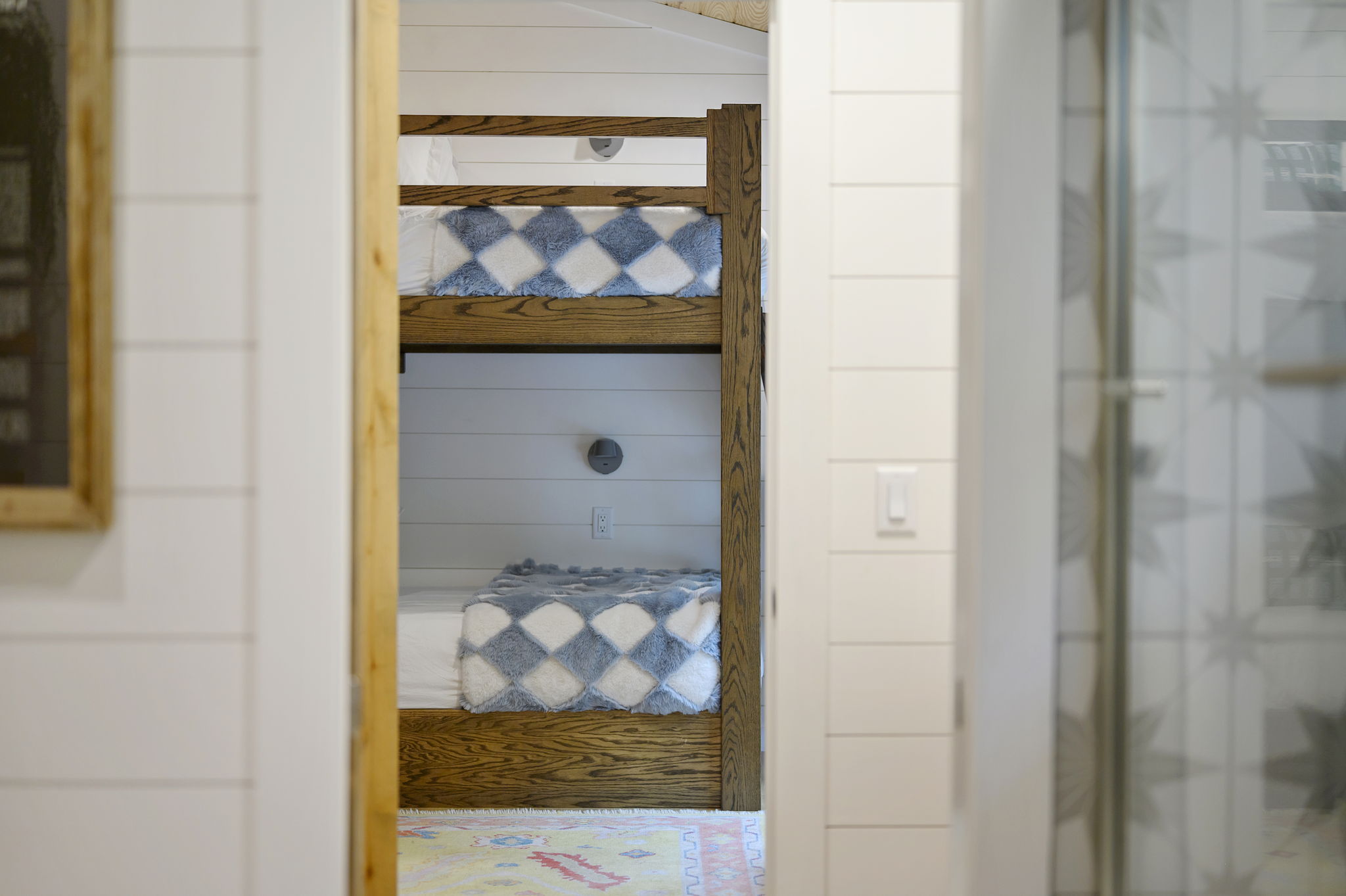 The stylish bunkroom features four twin beds, cozy designer touches, and high-end linens—creating a comfortable and welcoming retreat for kids or additional guests.