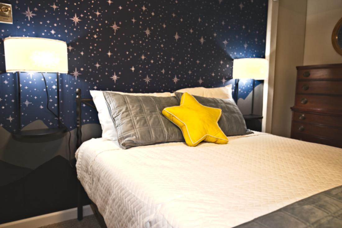 Drift into dreamland in this starry-themed bedroom, The Twilight Retreat, where cozy bedding and a playful pop of color create the perfect space for little adventurers—or the young at heart.Queen-sized bed with a new memory foam mattress.