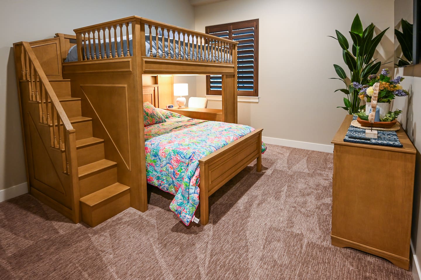 Two double beds with workspace with desk and chair off the side of the bunk bed