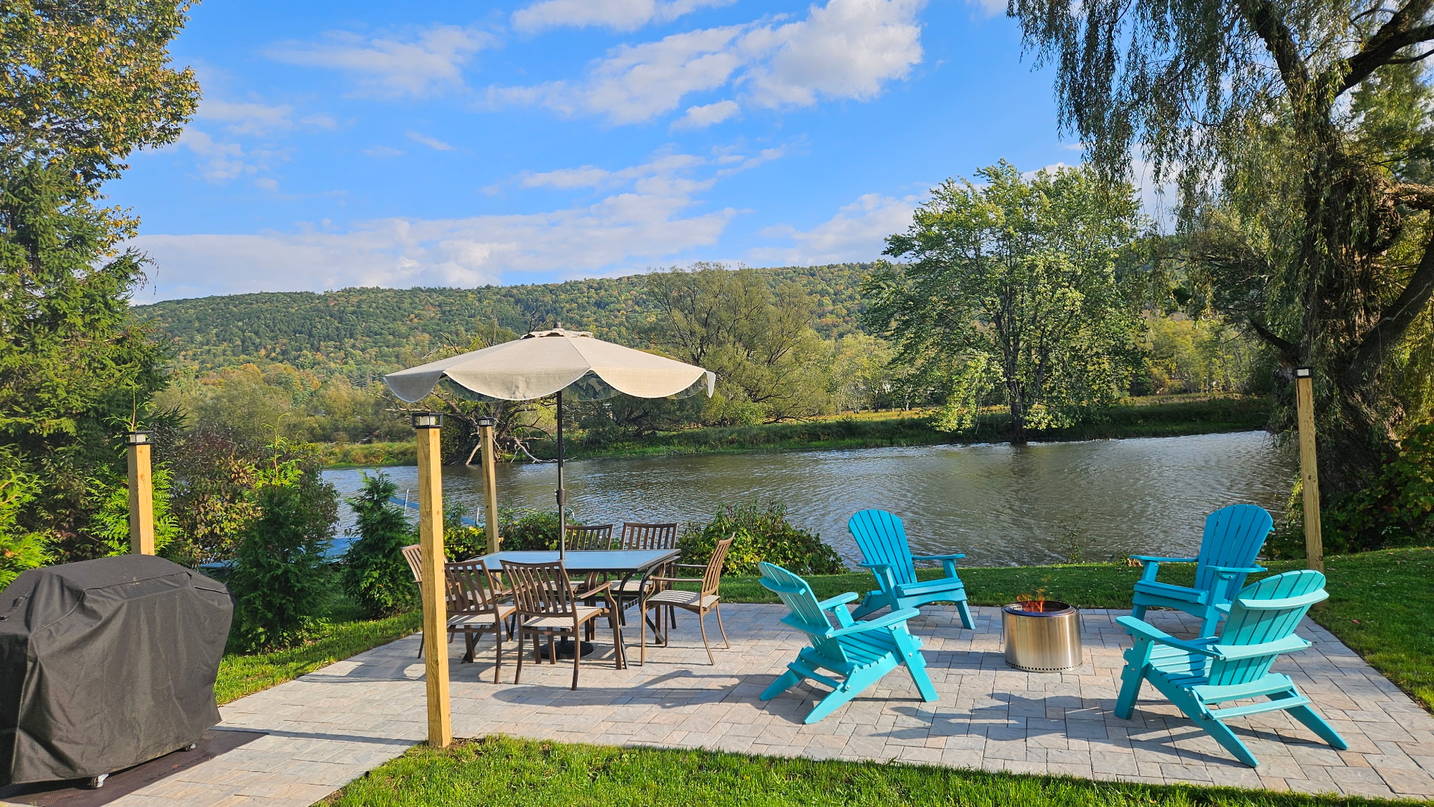 Backyard brick patio and firepit overlooking the beautifully calm water.