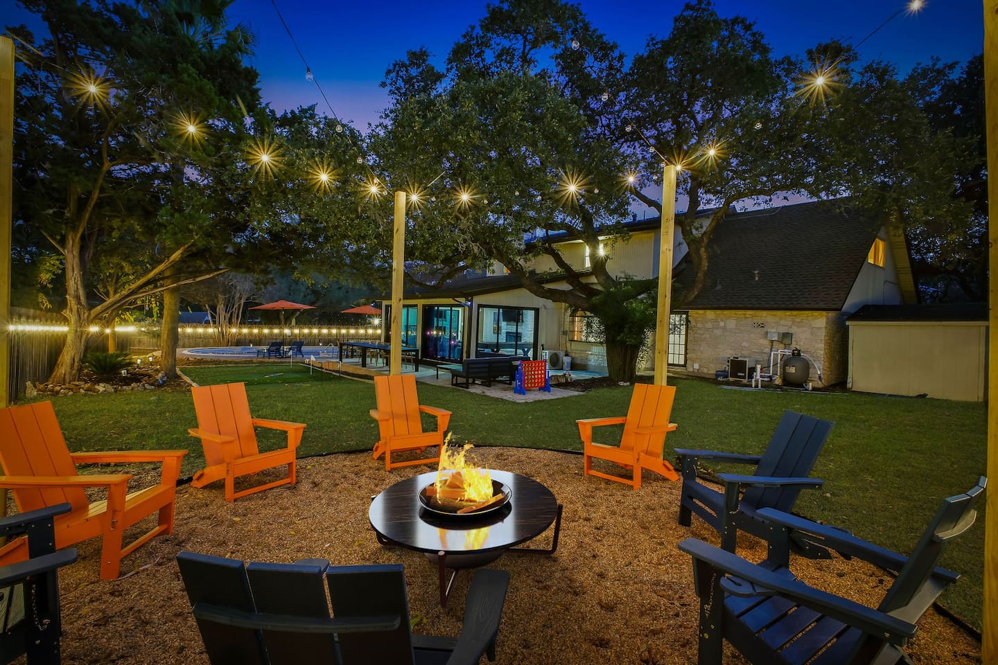 Gas fire pit with 8 chairs and cozy overhead string lights