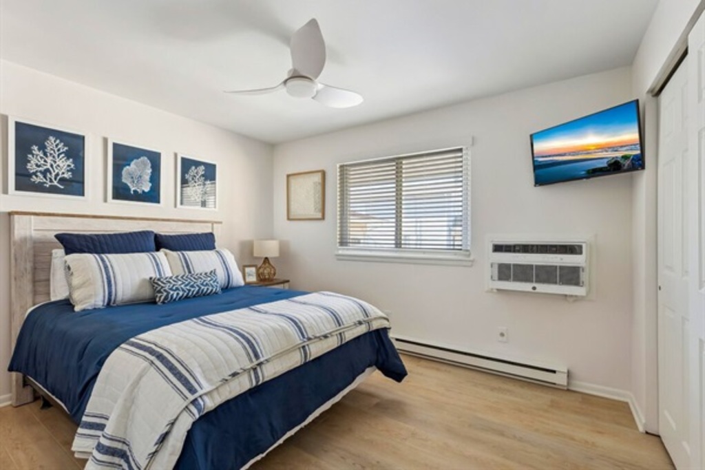 Comfortable queen room with a TV and window for fresh air.