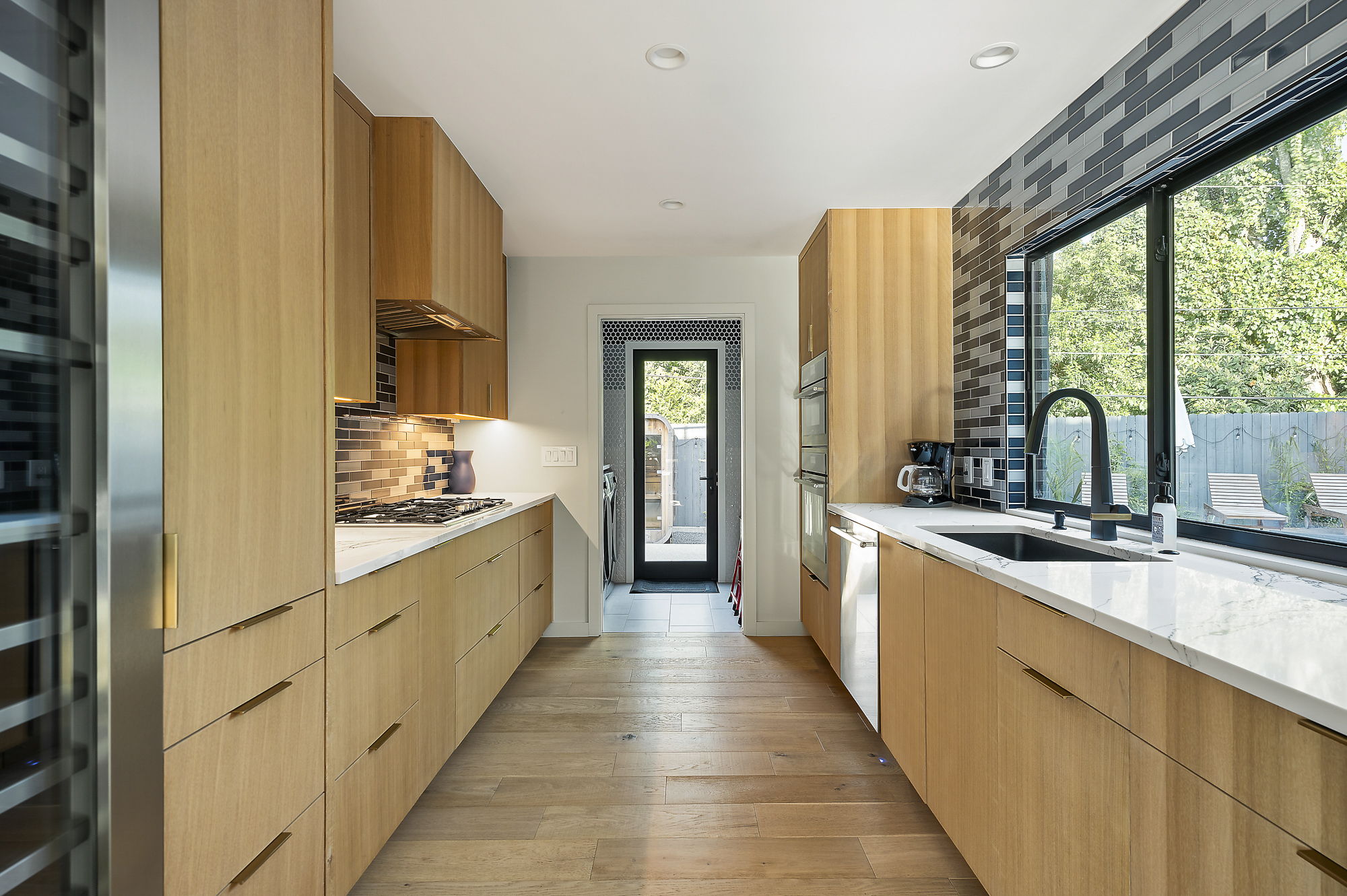 a modern kitchen with dark wood cabinetry and a second with light wood cabinetry