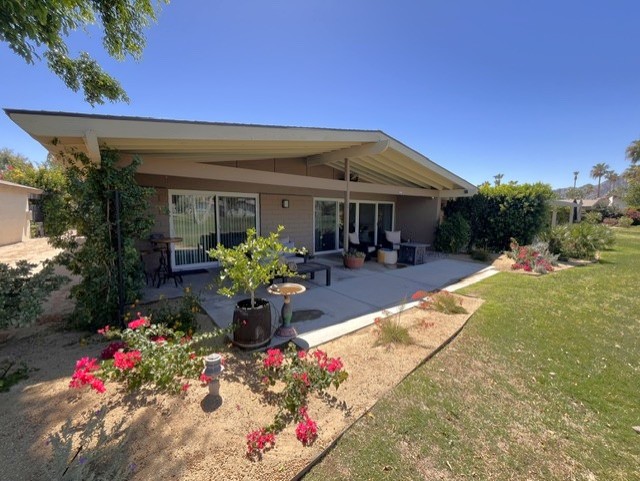 Covered patio with propane fire table, overhead fan, and soothing water feature.