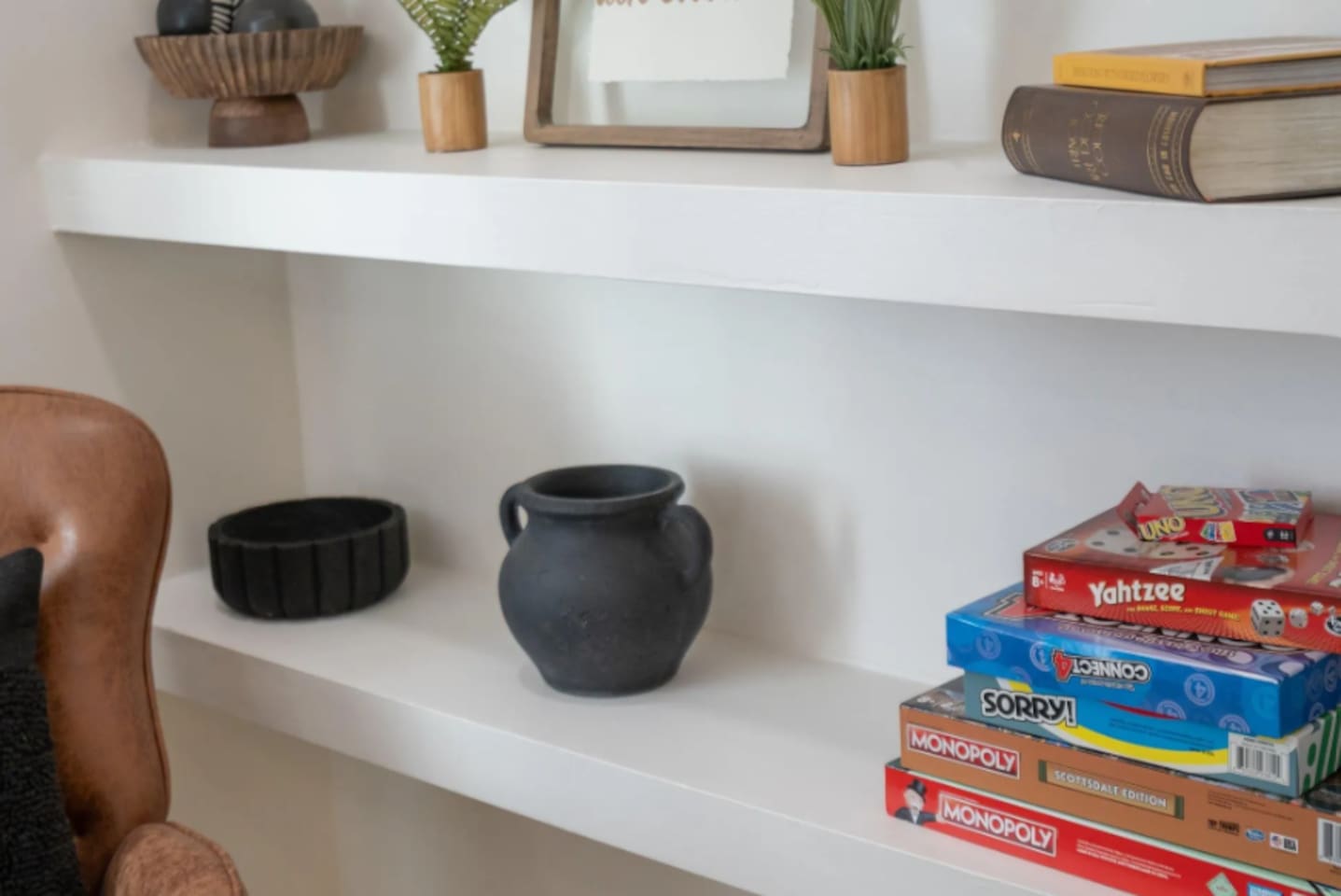 A curated shelf mixes decorative touches with classic board games, a small reminder that there's always something fun within reach.
