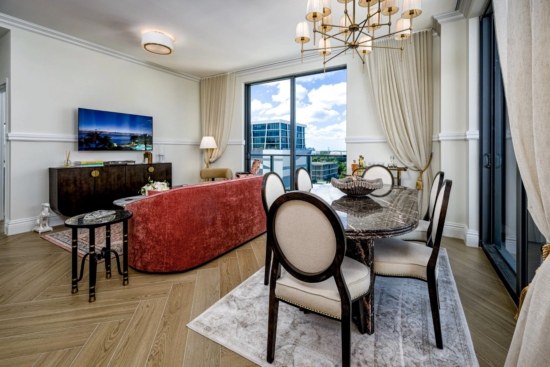 Dining area — seats 4 with chandelier and floor-to-ceiling Miami city views