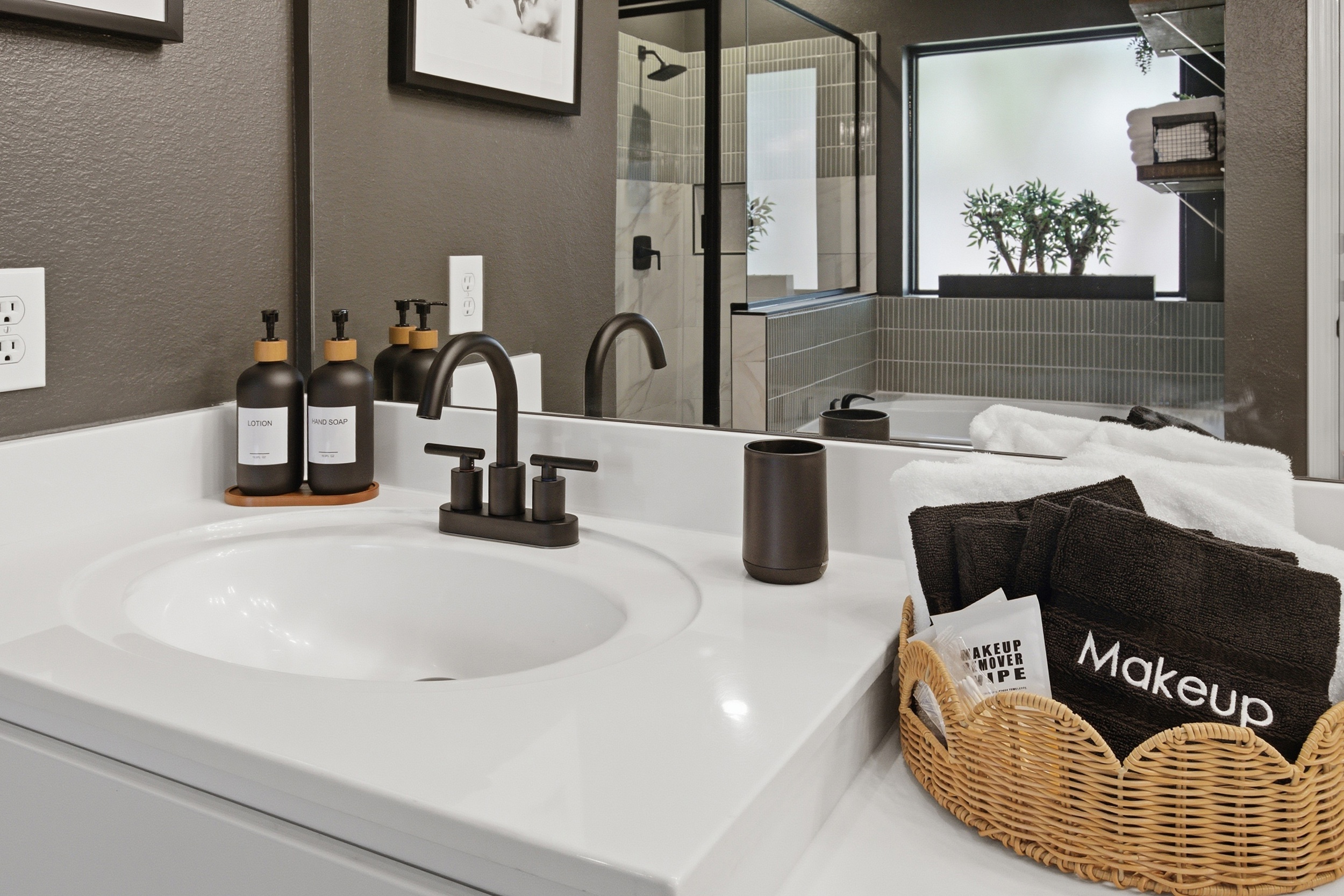 Thoughtfully curated countertops at the Master Bathroom Vanity, with hand soap, accessories, and a designated tray for guests. Stocked with essentials by Ginger Lily Farms.
