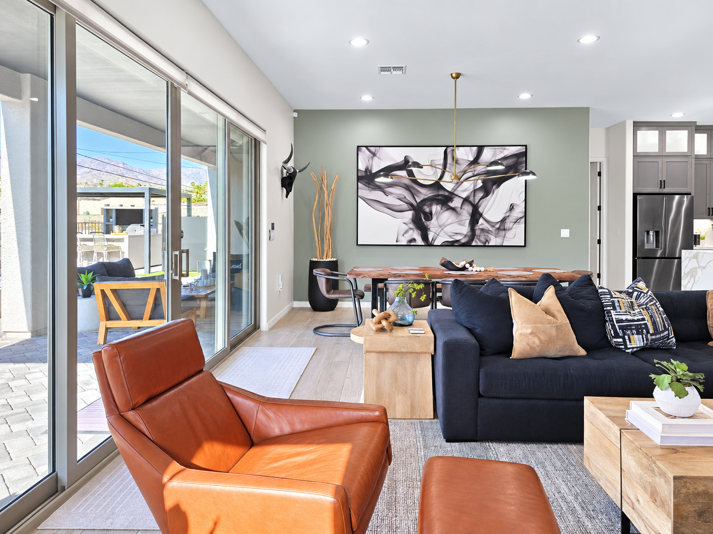 The living room flows seamlessly onto the outdoor patio, creating an effortless indoor-outdoor living experience.